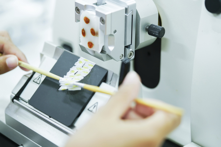 Photo shows tissue section being cut with a rotary microtome/Getty Images