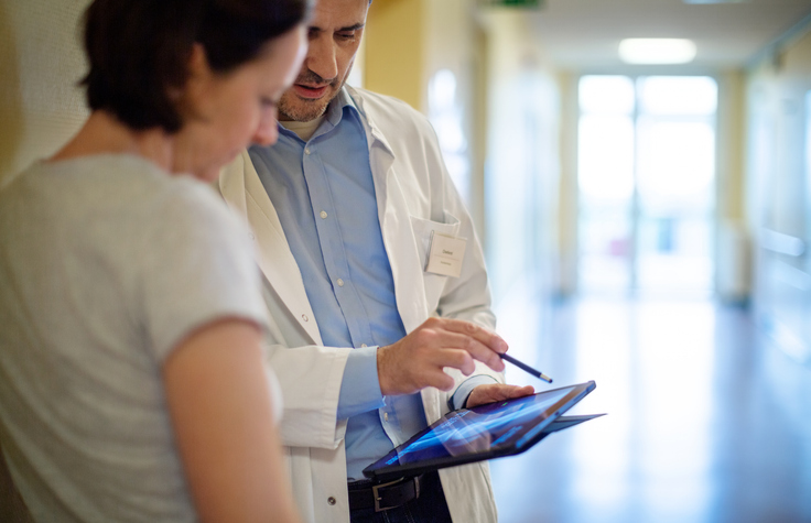 Orthopedic doctor showing X-ray to a patient/Getty Images