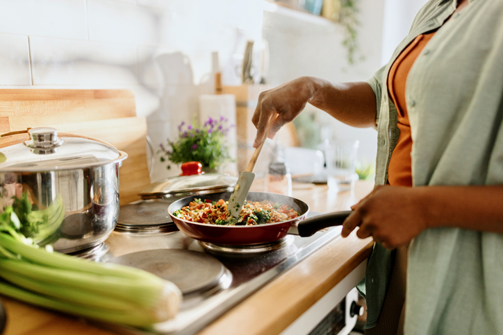 Photo shows a woman cooking a healthy quinoa stir-fry/Getty Images