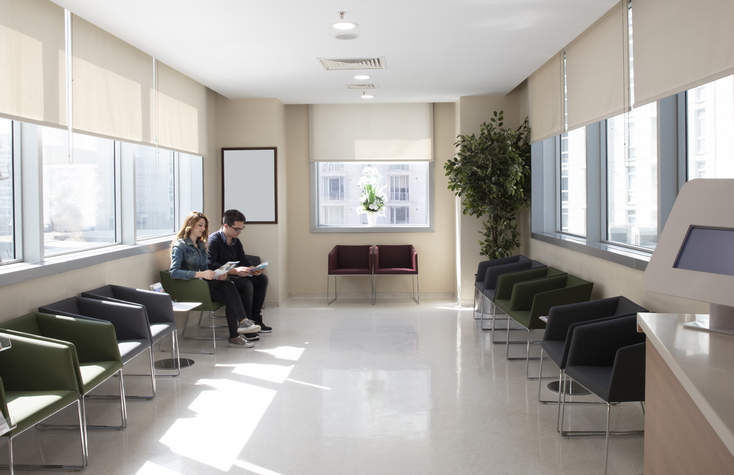 Photo shows a man and woman sitting in a hospital waiting room/Getty Images