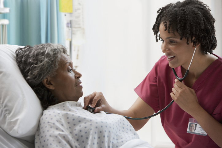 Photo shows nurse listening to patient's heart/Getty Images