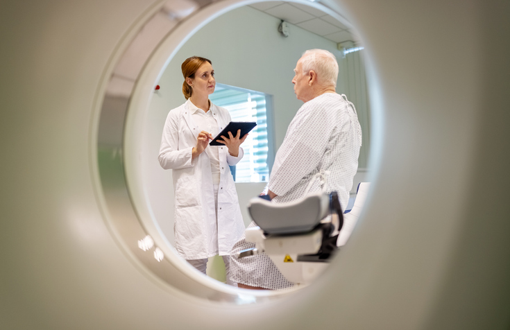 Photo shows radiologist preparing senior male patient for CT scan/Getty Images