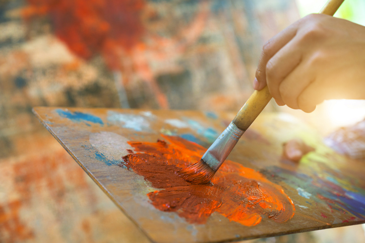 Photo shows an artist works on an abstract painting/Getty Images