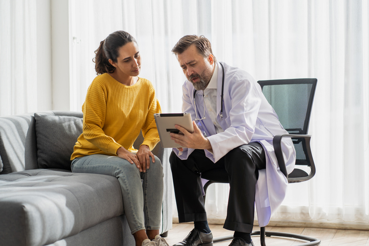 Photo shows a doctor talking with a patient about her diagnosis/Getty Images