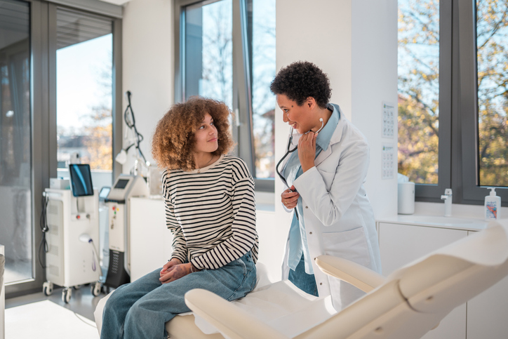 Photo shows a doctor consulting with her patient in a medical facility/Getty Images