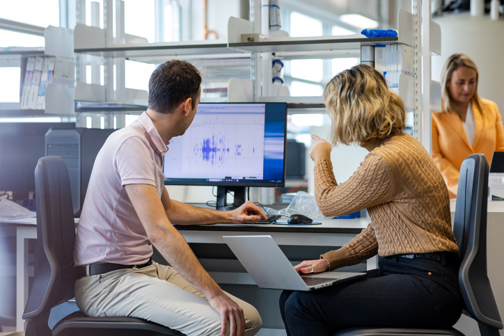 Photo shows two scientists analyzing data on a computer screen/Getty Images