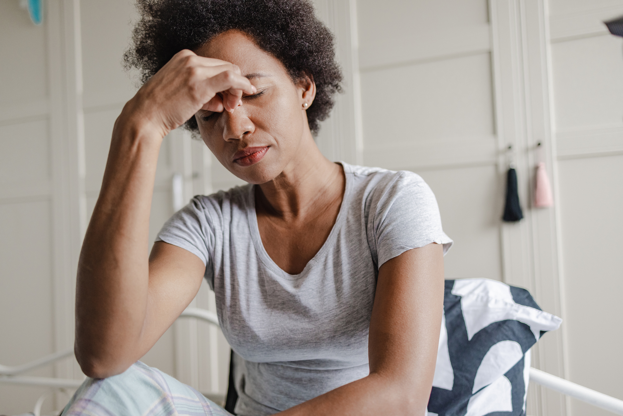 Photo shows a woman holding forehead